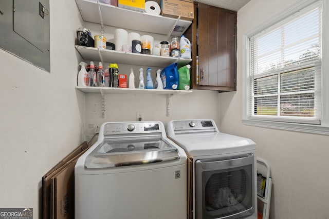 laundry area featuring cabinets, washing machine and clothes dryer, and electric panel