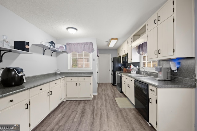 kitchen featuring sink, light hardwood / wood-style flooring, black appliances, and white cabinets