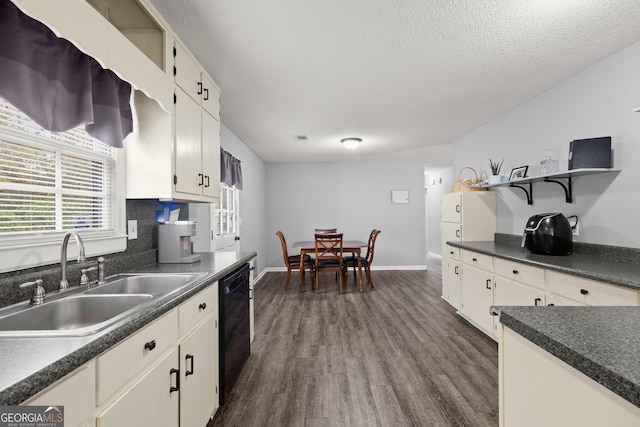 kitchen featuring backsplash, black dishwasher, sink, and white cabinets