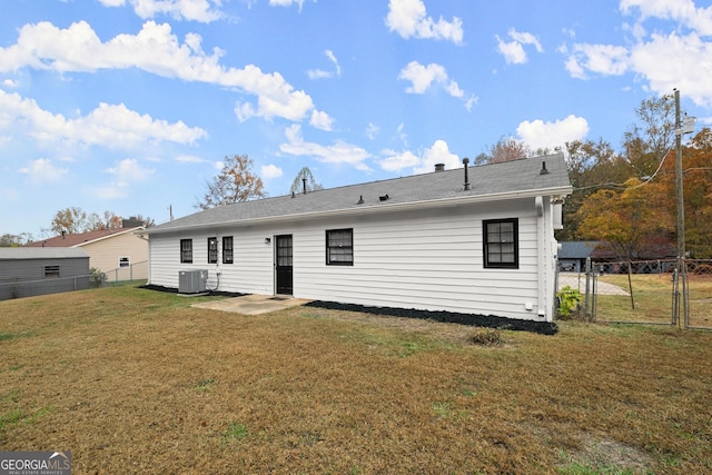 rear view of property featuring a yard, cooling unit, and a patio area