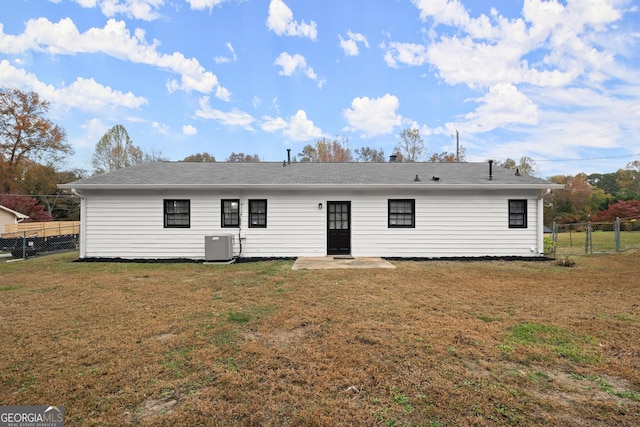 rear view of property featuring a yard and central AC