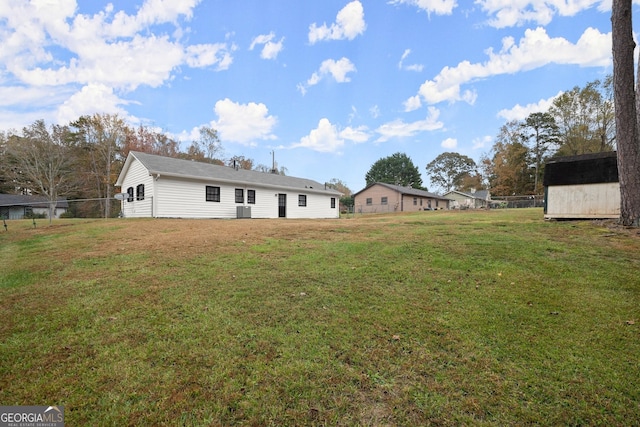 view of yard with central air condition unit and a storage shed