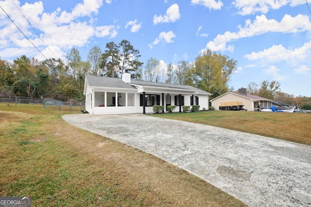 single story home featuring covered porch and a front yard