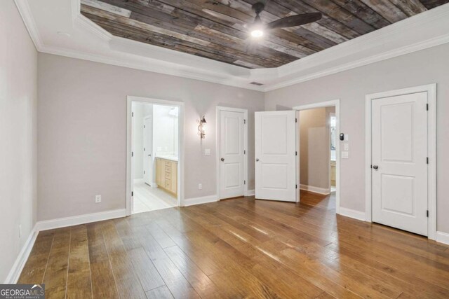 unfurnished bedroom with ensuite bath, wooden ceiling, crown molding, hardwood / wood-style floors, and a tray ceiling