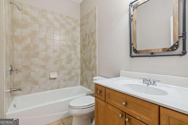 full bathroom with tile patterned flooring, toilet, vanity, and tiled shower / bath