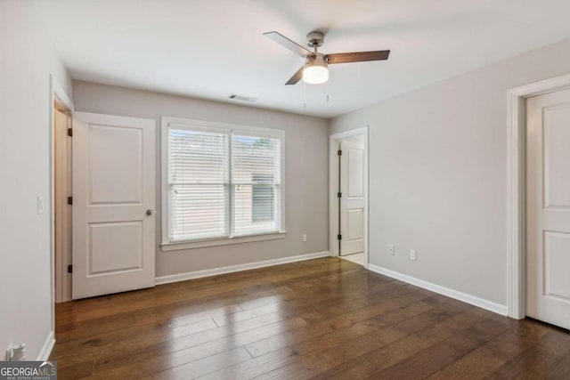 unfurnished bedroom featuring ceiling fan and dark hardwood / wood-style floors