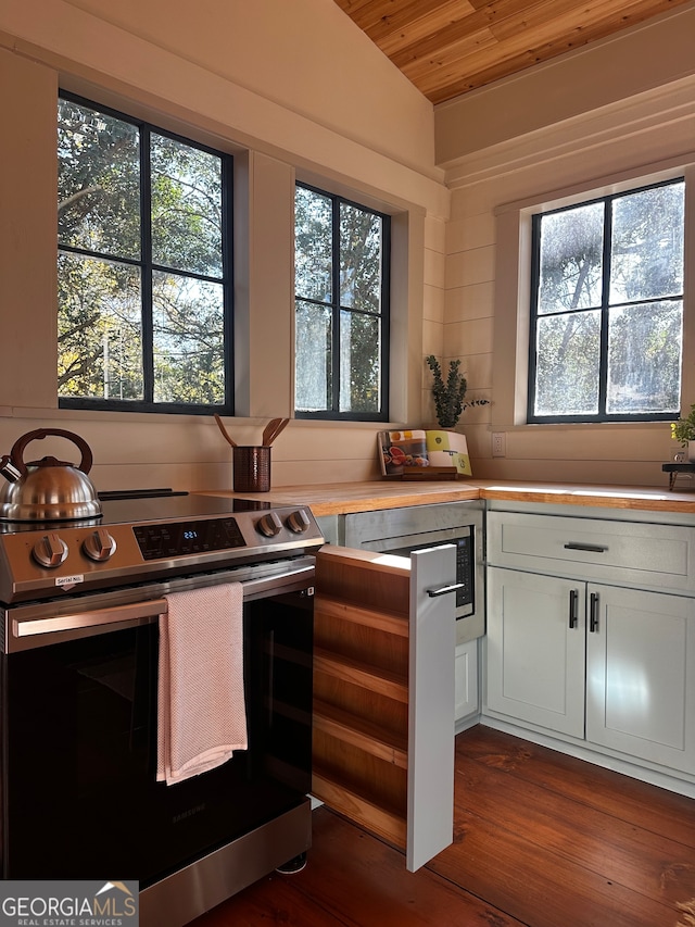 kitchen with lofted ceiling, dark wood-type flooring, stainless steel range oven, white cabinetry, and wood ceiling