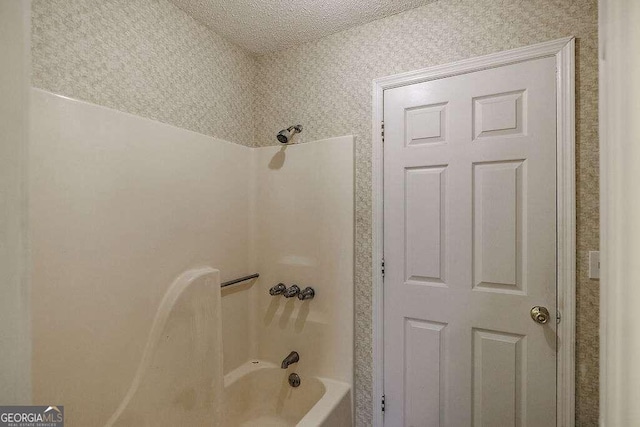 bathroom featuring shower / tub combination and a textured ceiling