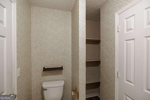 bathroom featuring a textured ceiling and toilet