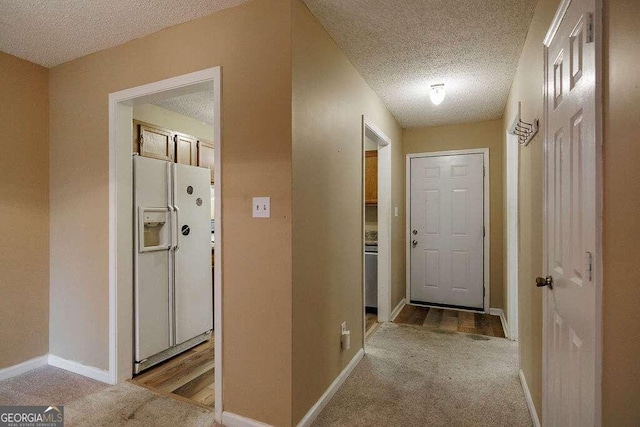 hall featuring light hardwood / wood-style floors and a textured ceiling