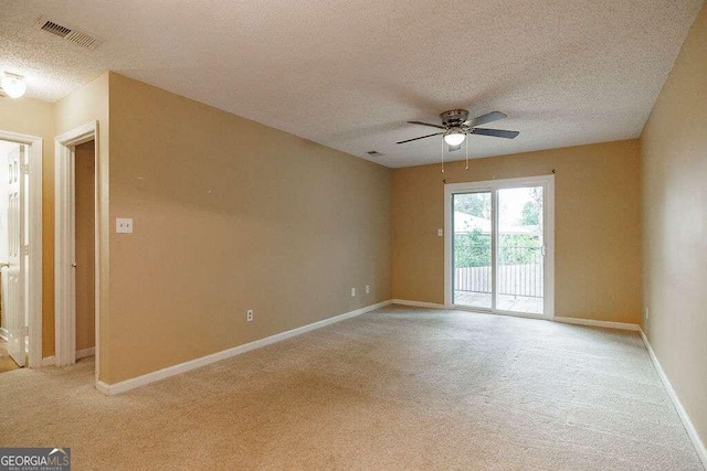 unfurnished room featuring a textured ceiling, light carpet, and ceiling fan