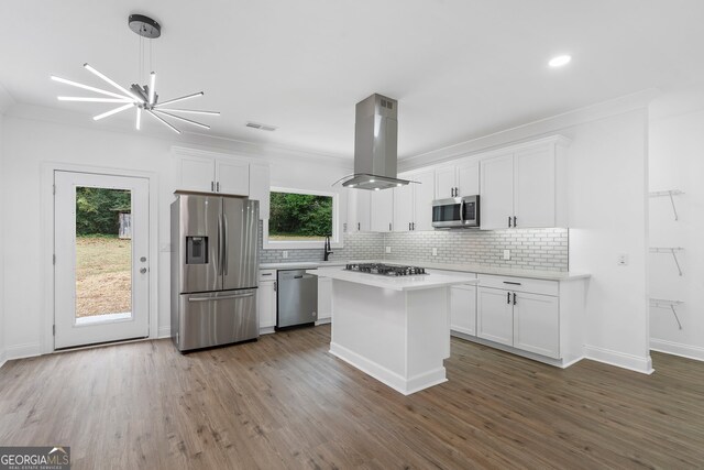 kitchen featuring island range hood, white cabinets, a healthy amount of sunlight, and stainless steel appliances