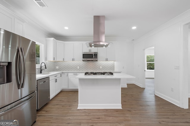 kitchen featuring white cabinetry, stainless steel appliances, hardwood / wood-style flooring, and a kitchen island