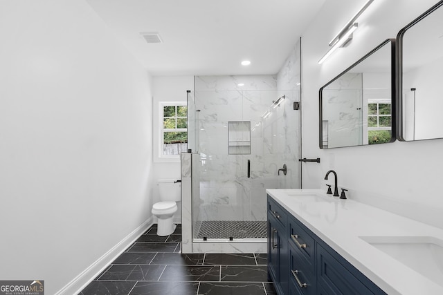 bathroom featuring toilet, vanity, and a shower with shower door