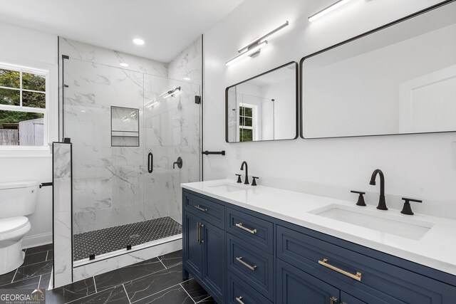 bathroom featuring vanity, toilet, and a shower with door