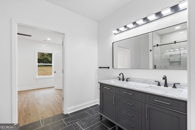 bathroom with hardwood / wood-style flooring, a shower with door, and vanity