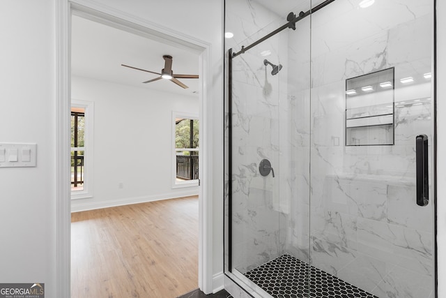 bathroom featuring wood-type flooring, ceiling fan, and a shower with door