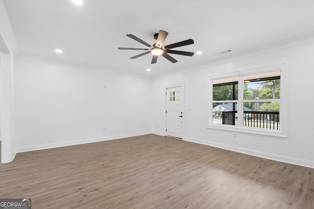 empty room featuring hardwood / wood-style flooring, ceiling fan, and crown molding