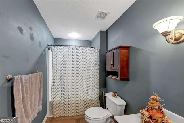 bathroom with toilet, a textured ceiling, tile patterned floors, and shower / bathtub combination with curtain