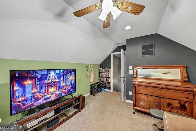 cinema with a textured ceiling, light carpet, ceiling fan, and vaulted ceiling