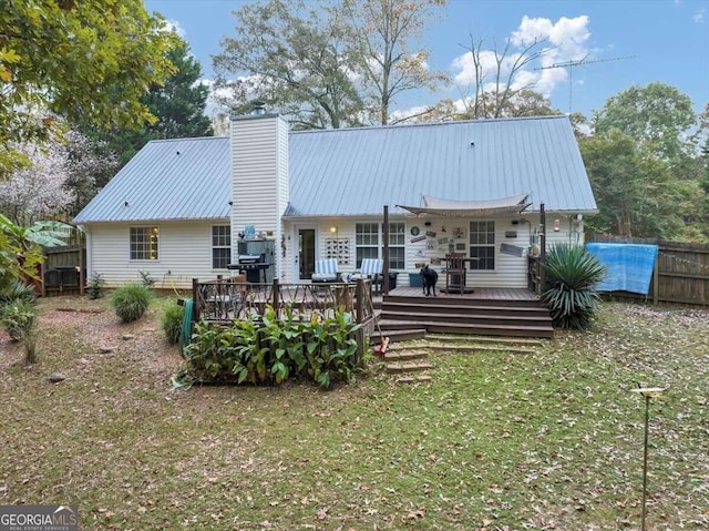 rear view of property with a yard and a wooden deck