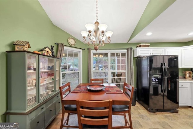 dining space with lofted ceiling and a notable chandelier