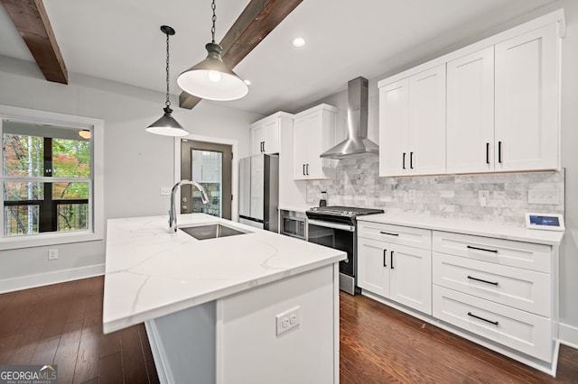 kitchen featuring stainless steel appliances, sink, white cabinets, wall chimney exhaust hood, and a kitchen island with sink