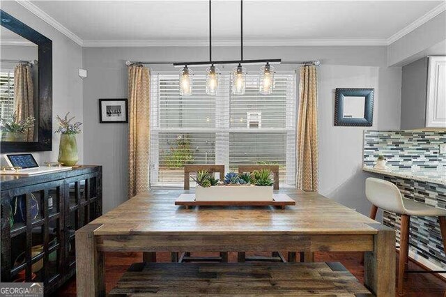 dining space featuring dark hardwood / wood-style flooring, sink, and ornamental molding