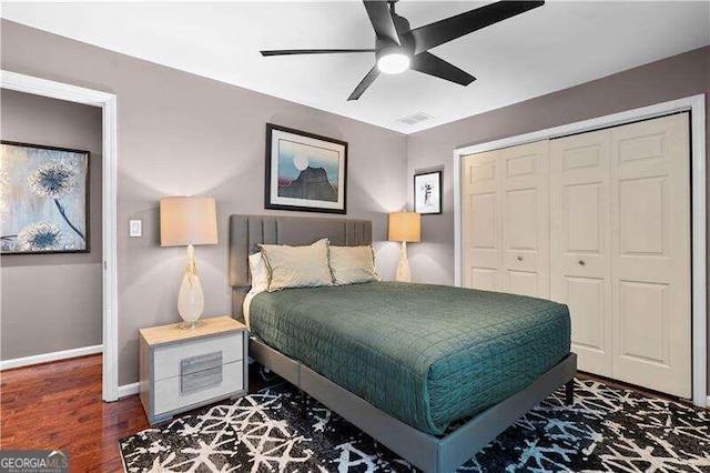 bedroom with dark hardwood / wood-style flooring, a closet, and ceiling fan