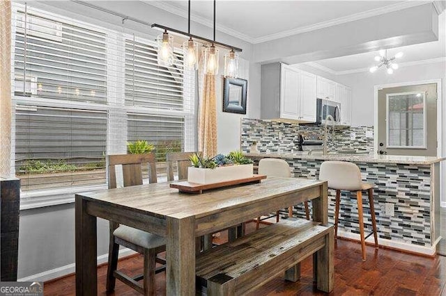 dining space with ornamental molding, a chandelier, and dark hardwood / wood-style floors