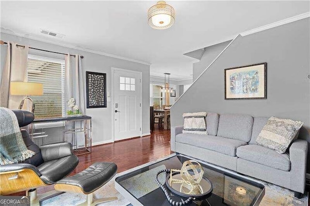 living room with dark hardwood / wood-style flooring and crown molding