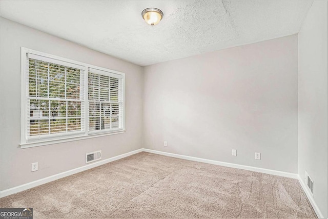 carpeted spare room featuring a textured ceiling