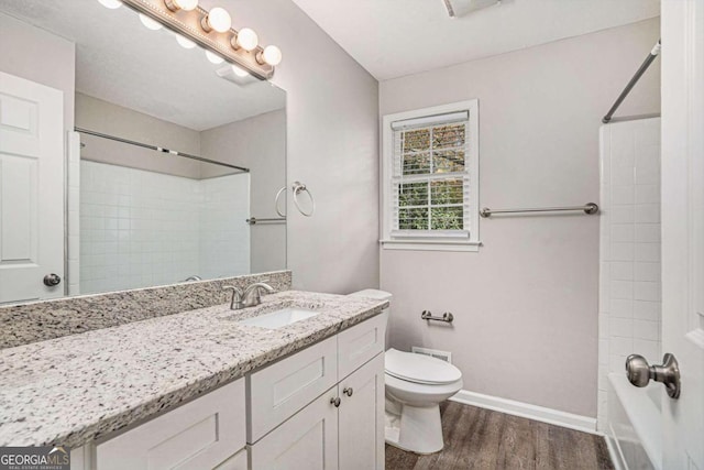 bathroom featuring walk in shower, vanity, hardwood / wood-style floors, and toilet