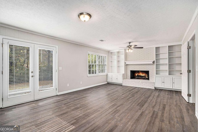 unfurnished living room with a brick fireplace, french doors, a textured ceiling, and dark hardwood / wood-style floors