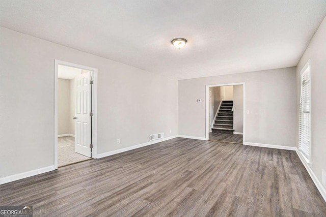 unfurnished room featuring dark hardwood / wood-style flooring and a healthy amount of sunlight