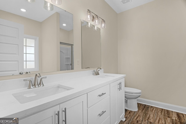 bathroom with hardwood / wood-style floors, a tub to relax in, vanity, and toilet