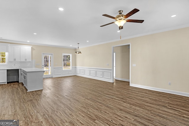 unfurnished living room with dark hardwood / wood-style flooring, sink, ceiling fan, and crown molding