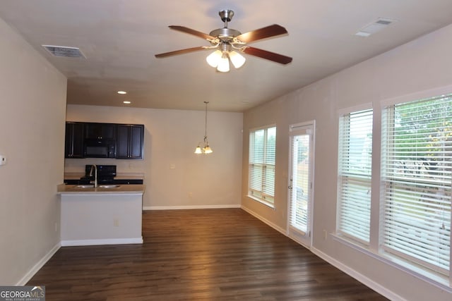 interior space featuring dark hardwood / wood-style floors, sink, and ceiling fan with notable chandelier