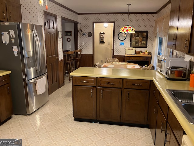 kitchen featuring ornamental molding, stainless steel refrigerator with ice dispenser, dark brown cabinetry, and hanging light fixtures