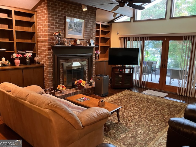 living room with french doors, a fireplace, hardwood / wood-style floors, and lofted ceiling