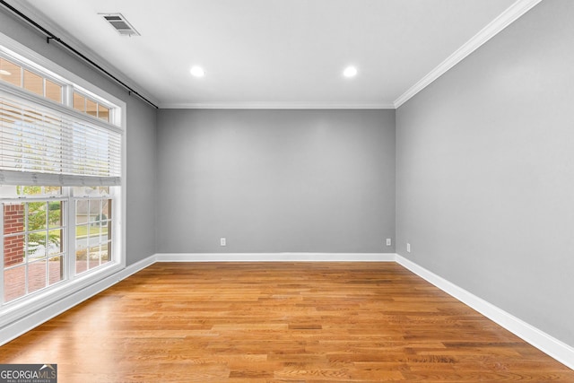 unfurnished room with light wood-type flooring and ornamental molding