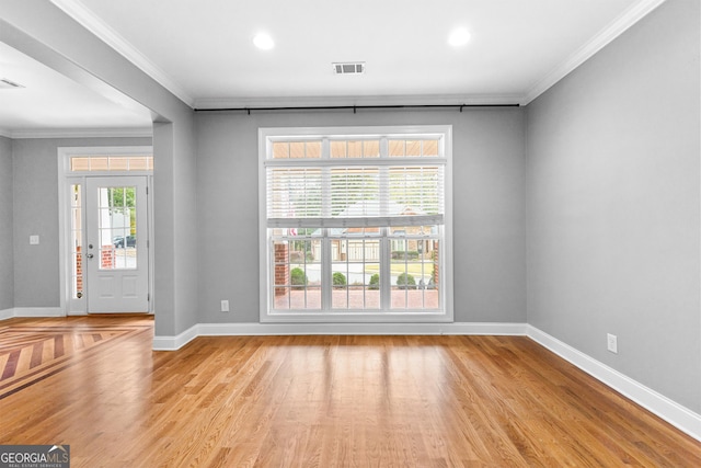 interior space featuring light hardwood / wood-style flooring, a wealth of natural light, and ornamental molding