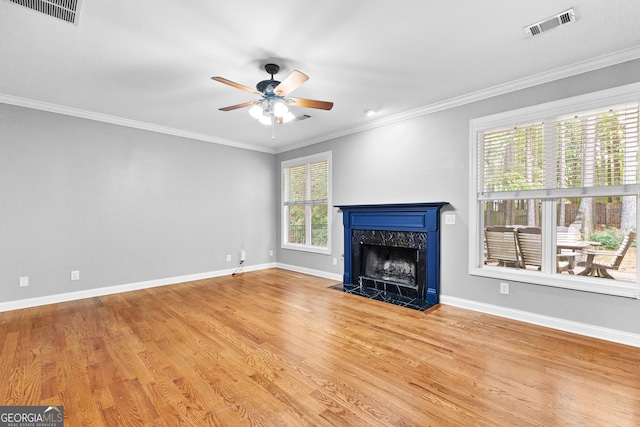 unfurnished living room with ceiling fan, light hardwood / wood-style floors, crown molding, and a high end fireplace