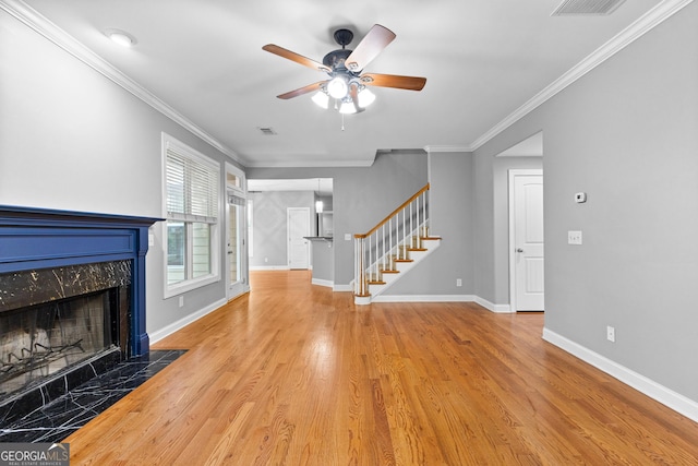 unfurnished living room with a fireplace, ceiling fan, wood-type flooring, and crown molding