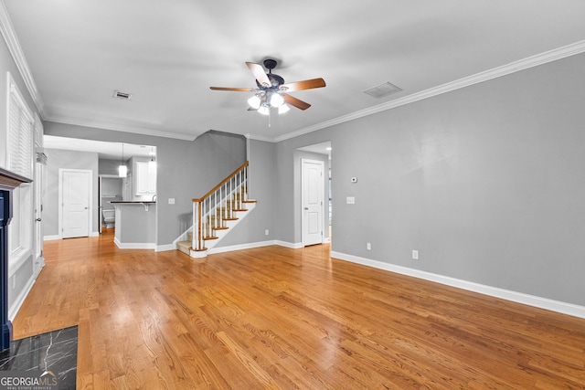 unfurnished living room featuring ceiling fan, wood-type flooring, and ornamental molding