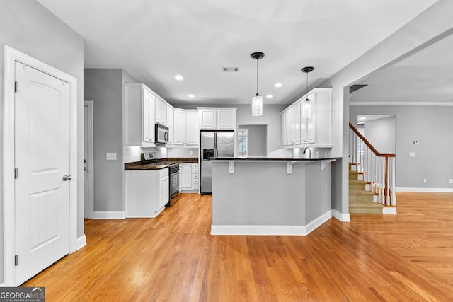 kitchen featuring white cabinetry, stainless steel appliances, kitchen peninsula, a breakfast bar area, and light wood-type flooring