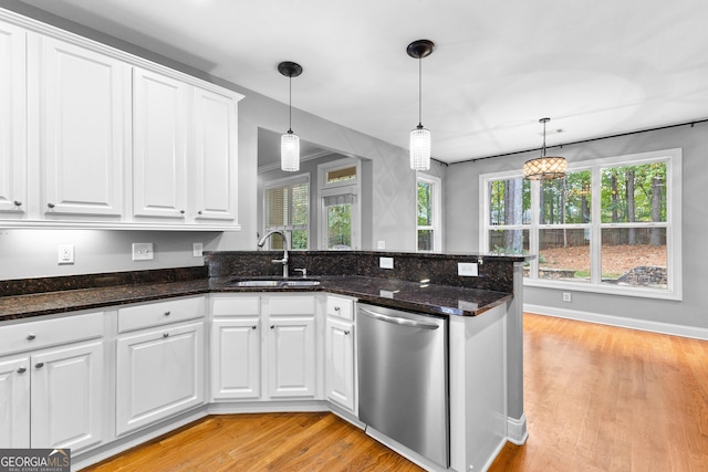 kitchen featuring dishwasher, sink, white cabinets, and hanging light fixtures