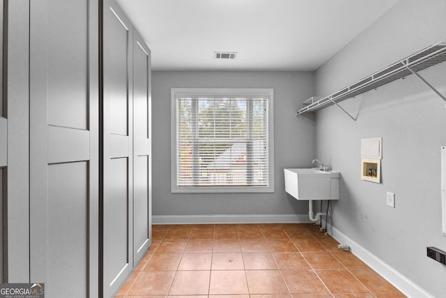 laundry room featuring washer hookup and light tile patterned floors