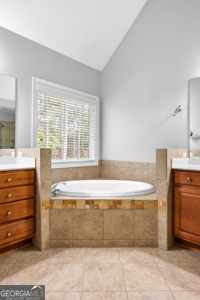 bathroom featuring tile patterned flooring, vanity, high vaulted ceiling, and tiled tub