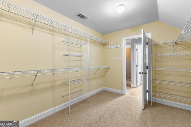 walk in closet with carpet flooring and lofted ceiling